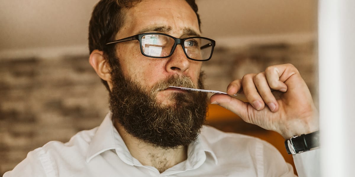 nervous bearded man fidgeting with credit card dealing with alcoholism and depression