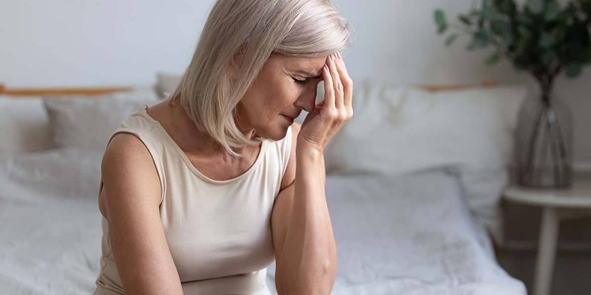 a woman puts her hand to her head as she considers the klonopin side effects