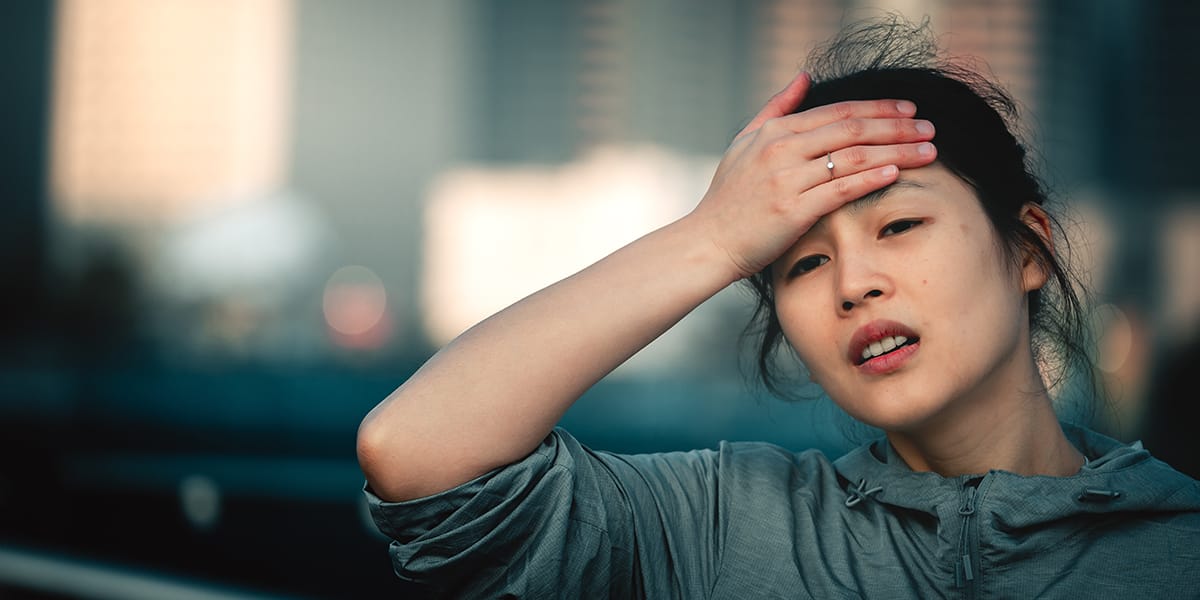 woman holding forehead getting dope sick