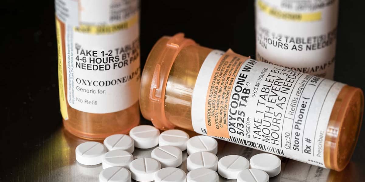 prescription painkiller bottles and pills to make you question the symptoms of painkiller addiction