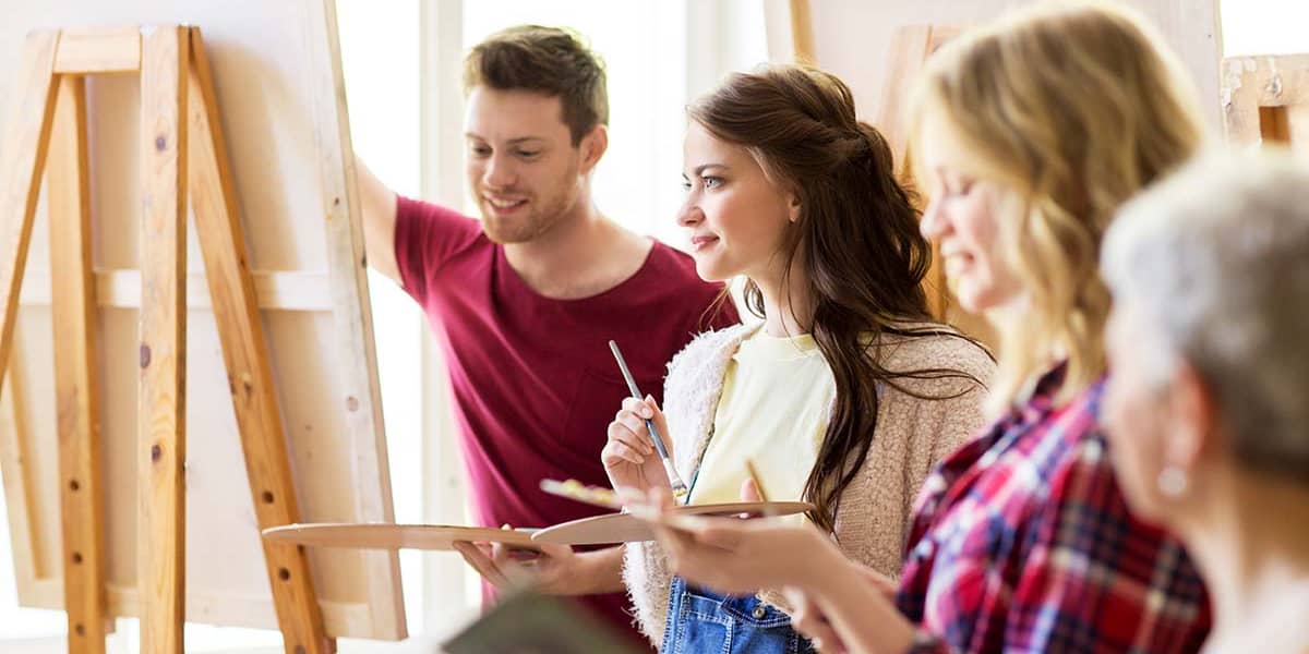 group of people working on canvas painting and getting art rehab therapy benefits