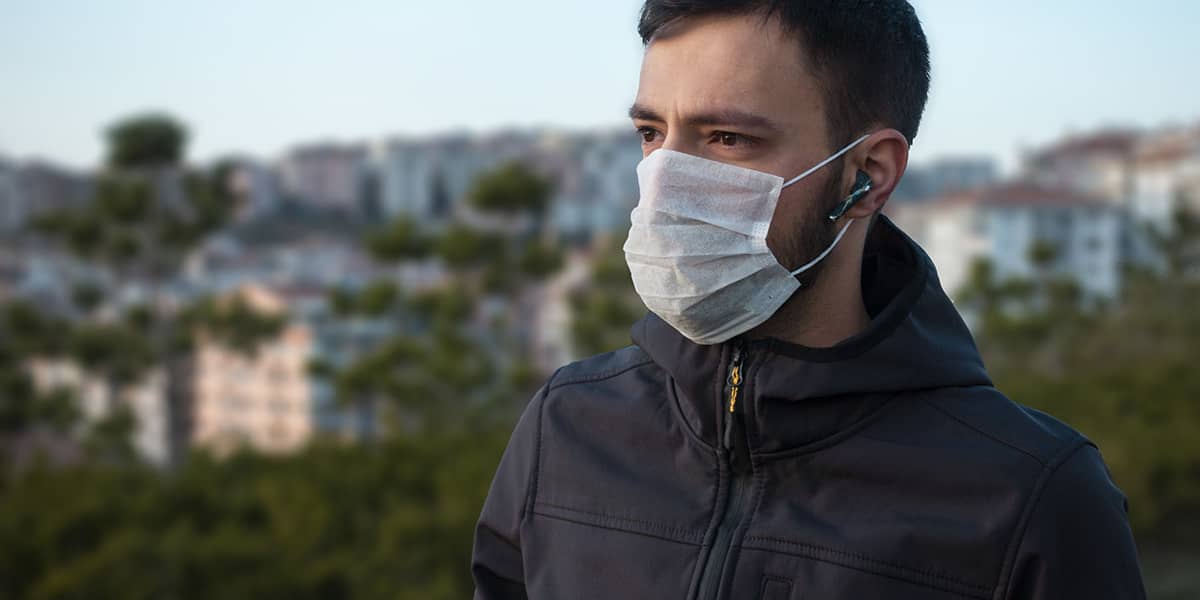 man outside wearing mask knowing difference between epidemic vs pandemic