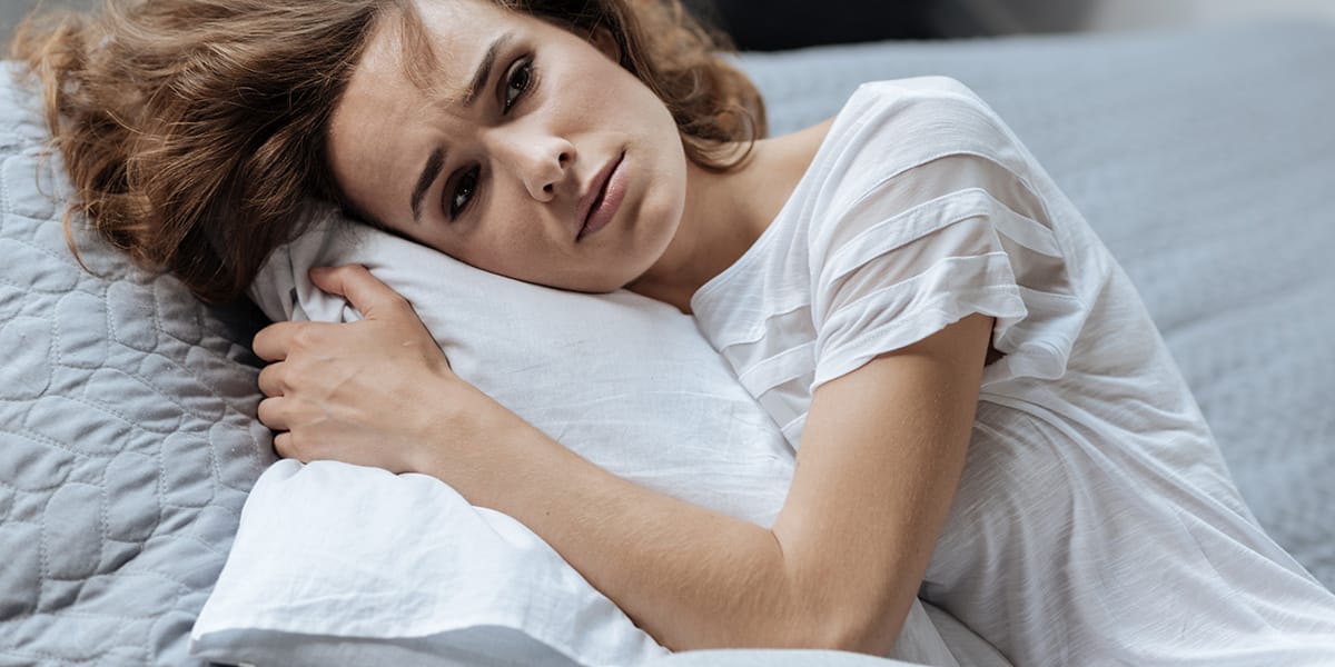 woman hugging pillow struggling with Post Acute Withdrawal Syndrome