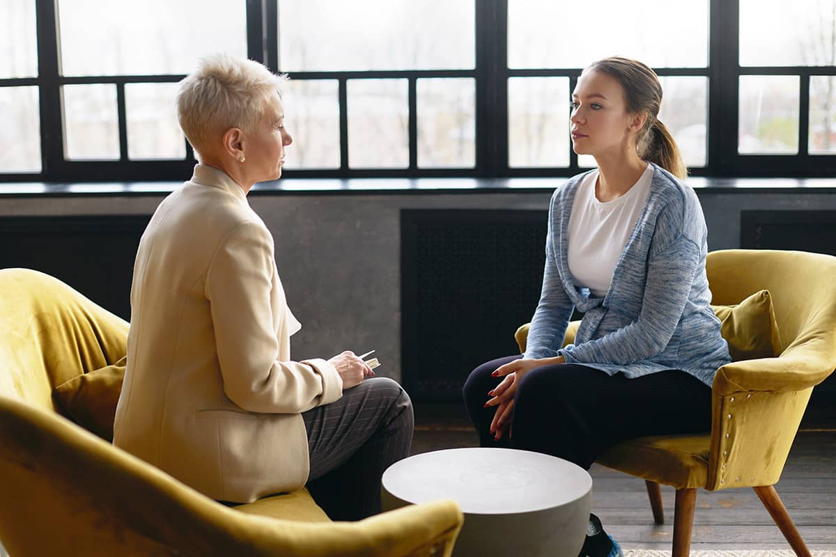 a doctor explaining to a young patient the psychotherapy definition in addiction counseling