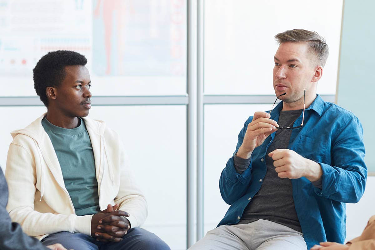 men discussing the benefits of mens drug rehab