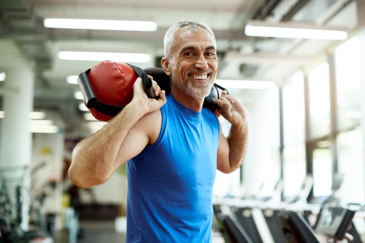 smiling man utilizing the gym membership at Crestview Recovery to partake in exercise and recovery