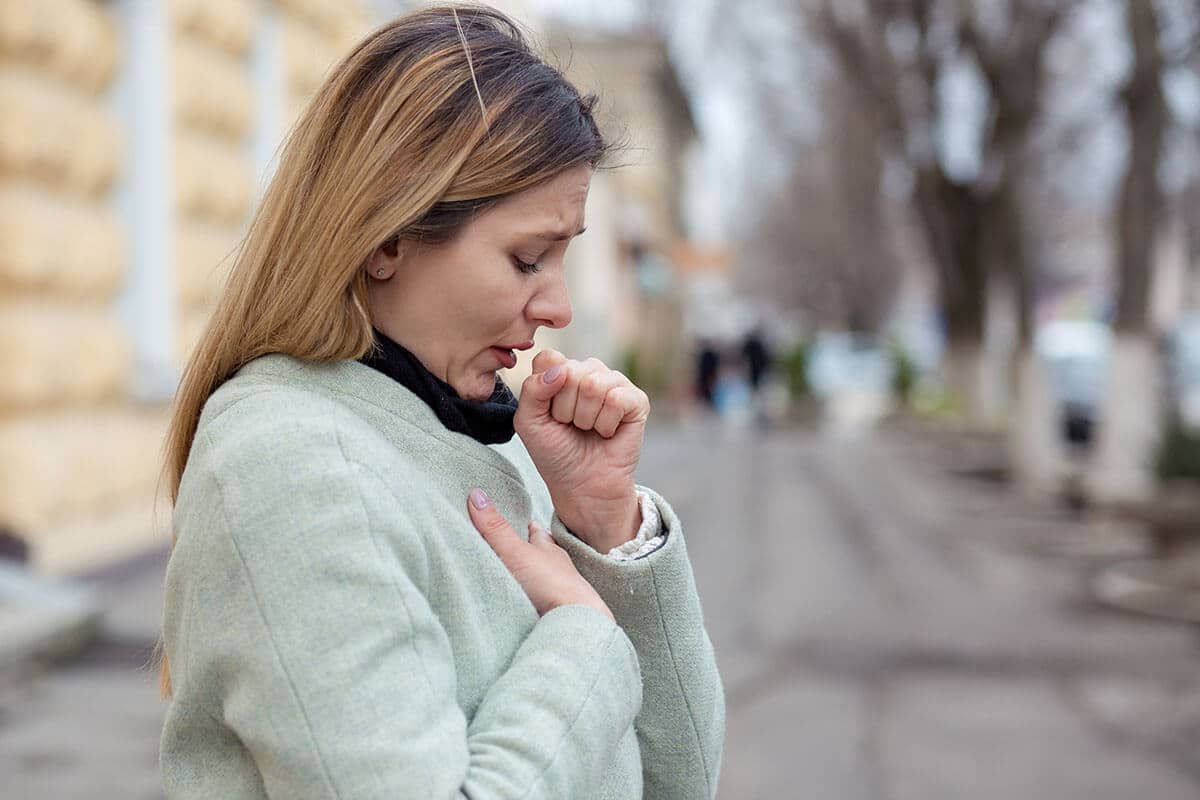 a woman coughs because she has a compromised immune system