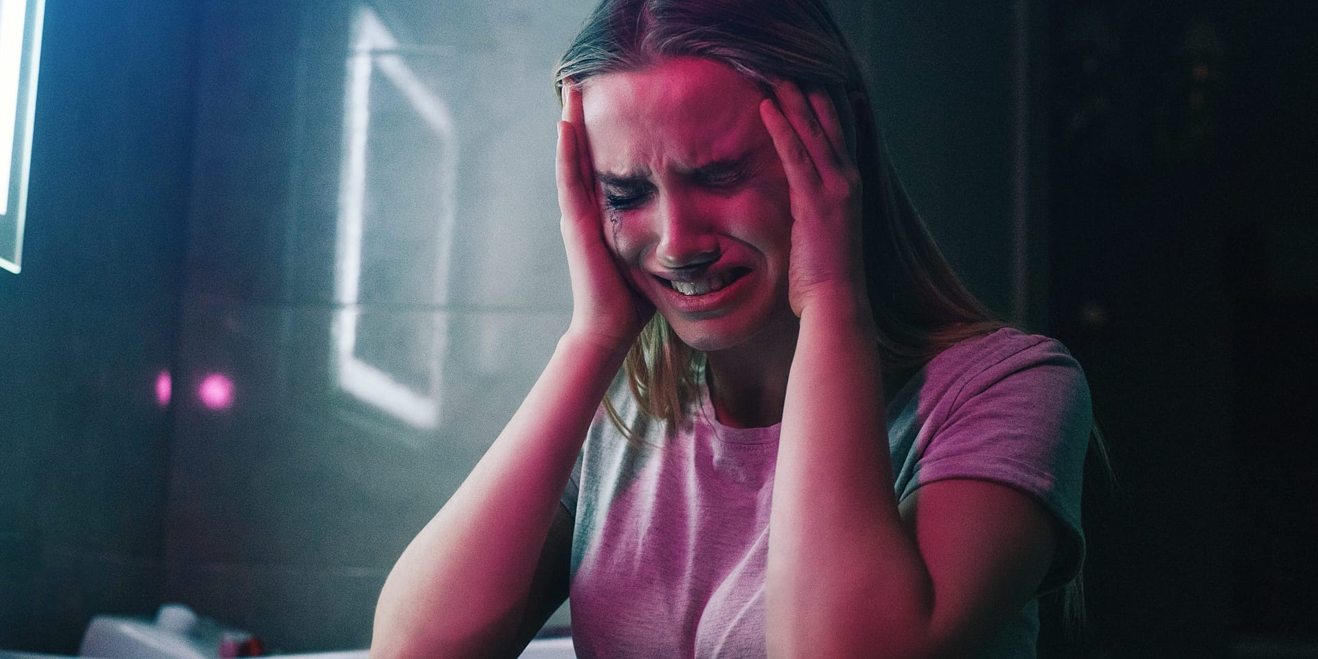 woman holding her head and crying from symptoms of heroin addiction needing a heroin detox center in florida