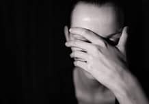 Person in dark with hand on face needs a rehab center like Beaches.