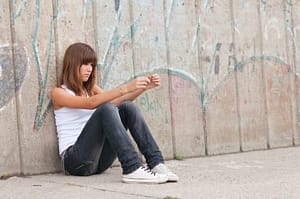 Young women sitting by the fence may be on the fence asking how to detox from meth addiction
