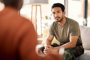 a veteran talks to a therapist in a military and veteran rehab program