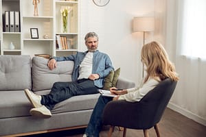 a man talks to a therapist during trauma treatment