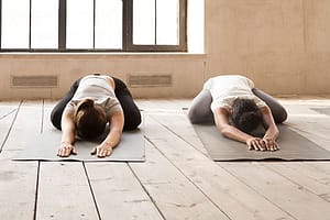two people do yoga in a yoga therapy program