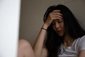 Woman leans against wall, struggling with cocaine withdrawal symptoms