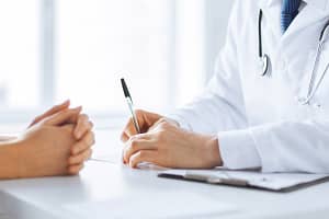 Doctor takes notes as client lists off their commonly abused substances