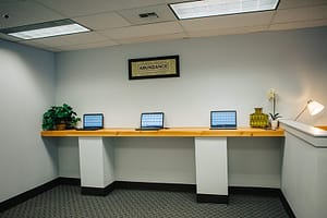 Row of communal laptops in an office at Bayview Recovery Center