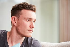 Man looking worried when he notices his stages of addiction.