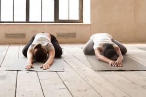 two people do yoga in a yoga therapy program
