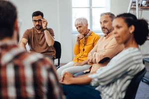 People listen attentively during group in a painkiller rehab program