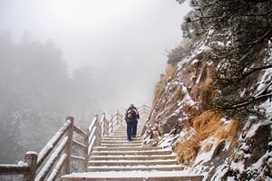 person climbing up a mountain taking steps towards recovery