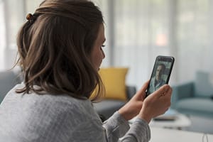 Woman talks to therapist on phone as she discovers the many benefits of telehealth treatment