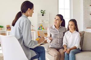 Therapist talks to mother and daughter about trauma signs