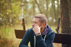 Man on bench contemplating whether his addiction started with a gateway drug.