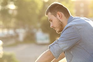 Man sitting outside concerned about his opioid dependence.