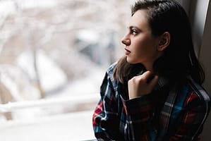 Girl in flannel shirt in winter dealing with sober living drug rehab.