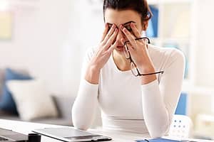 Woman at desk struggling to stay awake may be showing signs of employee drug use