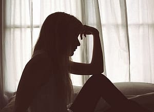Depressed woman in silhouette after researching opiate detox centers