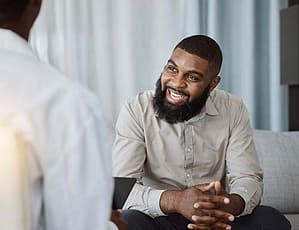 therapist explaining the benefits of ketamine nasal spray to smiling man