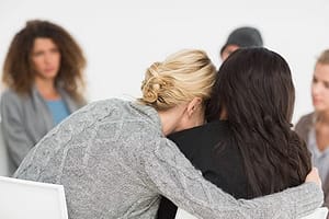 Two women understanding each other at an addiction recovery group.