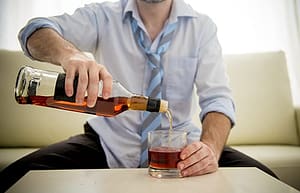 Man in tie pouring a drink should know is alcohol a stimulant or depressant.