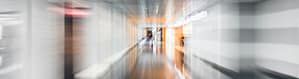 A blurry hospital hallway symbolizing how the latest tech and AI adoption needs change management from the start