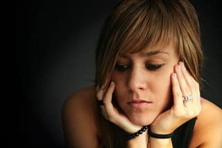 Sad young woman in the dark needs a methadone detox center program