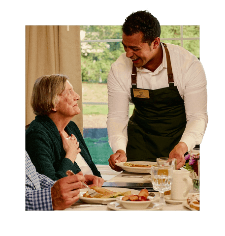 Server bringing food to senior