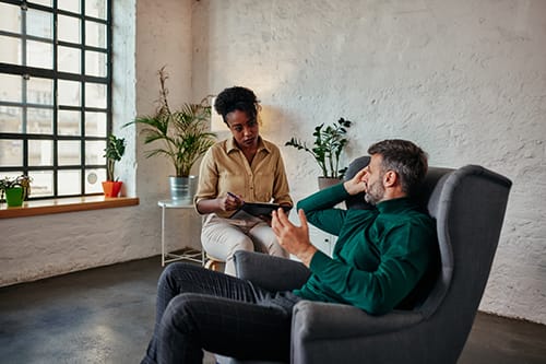 a man talks with a therapist about the benefits of individual counseling