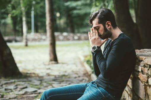 Stressed out young man sitting in a park