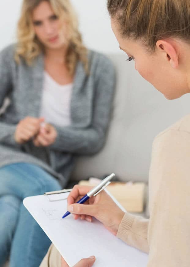 a woman talks to a therapist at a dual diagnosis treatment program