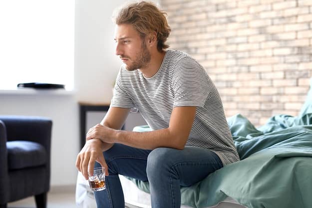 Man drinking and thinking about the dangers of binge drinking