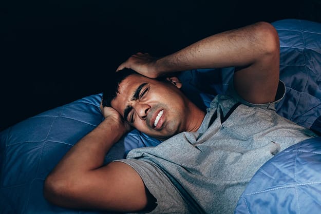 Man in bed experiencing drug withdrawal symptoms
