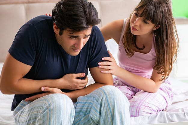 woman holding her sick husband thinking my husband drinks too much