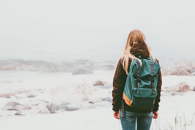 woman backpacking during the stages of addiction recovery