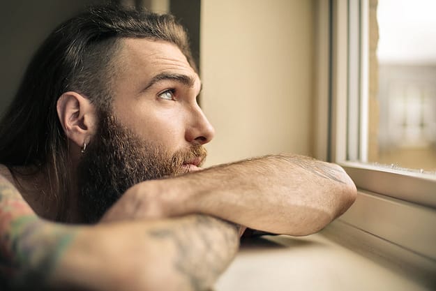 man looking out window needing drug addiction recovery