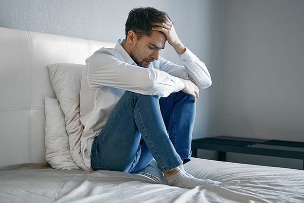 a man holds his head as he struggles with fentanyl side effects