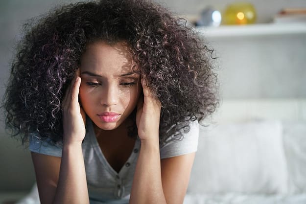 woman holding hands to head after learning what xanax does