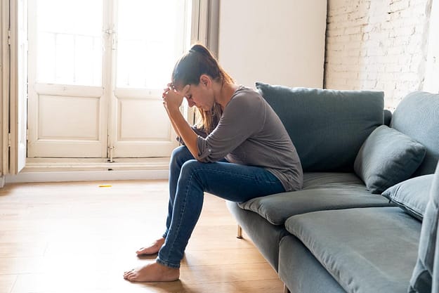 woman struggling and sitting on couch with ketamine high