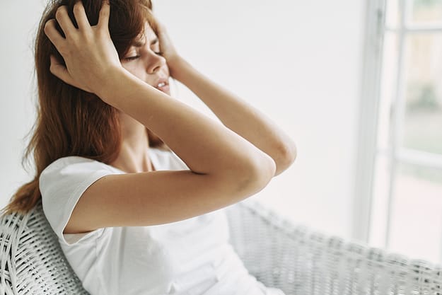 woman holding her head dealing with myths about addiction