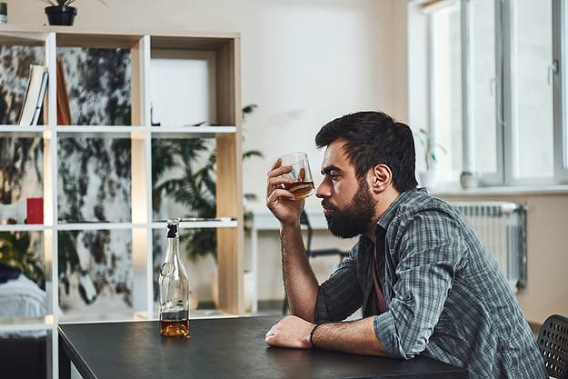 Man sits and wonders how to define alcoholism